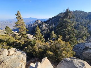 A view of a mountain range from a cliff

Description automatically generated