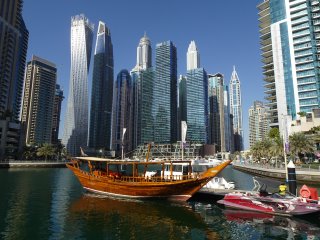 A boat in the water with tall buildings in the background

Description automatically generated with low confidence