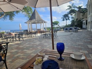 A table with blue glasses and white umbrellas on a patio

Description automatically generated