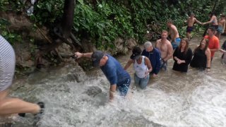 A group of people in a river

AI-generated content may be incorrect.