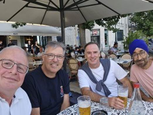 A group of men sitting at a table with drinks

Description automatically generated with medium confidence