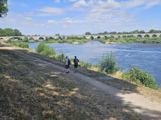 A couple of people walking on a path by a river

Description automatically generated with low confidence