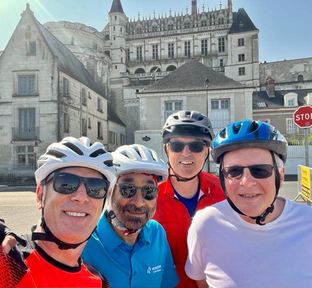 A group of people wearing helmets and standing in front of a building

Description automatically generated