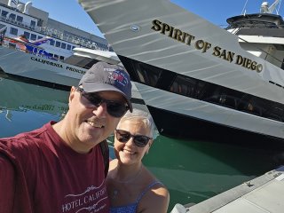 A person and person taking a selfie in front of a boat

Description automatically generated