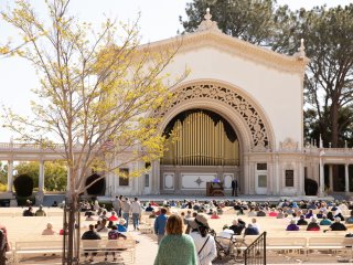 A group of people sitting in a plaza

Description automatically generated