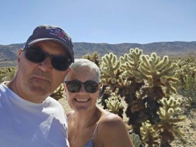 A person and person taking a selfie in front of cactus

Description automatically generated