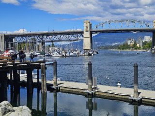 A bridge over water with boats in the background

Description automatically generated