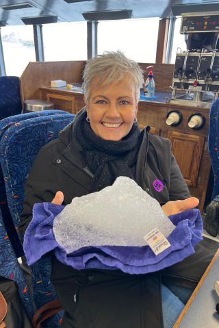 A person holding a piece of ice

Description automatically generated