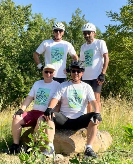 A group of men wearing helmets and sitting on a rock

Description automatically generated