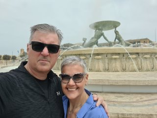 A person and person posing for a photo in front of a fountain

Description automatically generated