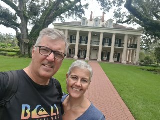 A person and person smiling in front of a white house

Description automatically generated with medium confidence