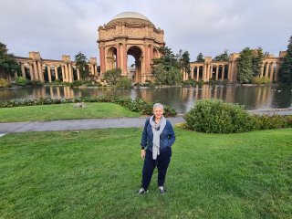 A person standing in front of a building with a fountain in front

Description automatically generated with low confidence