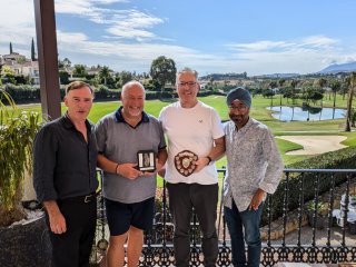 A group of men standing on a balcony with a trophy

Description automatically generated